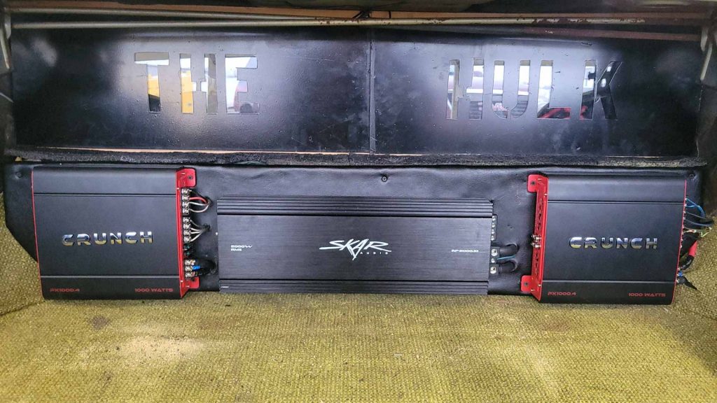 Car audio system installed by Hear Me Coming Car Audio with products from Crunch and Skar Audio. Text on the custom enclosure reads "The Hulk"