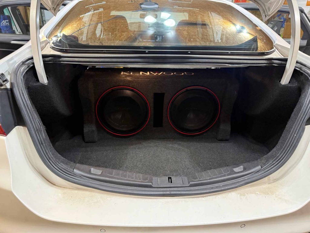 Large Kenwood subwoofer installed in car trunk
