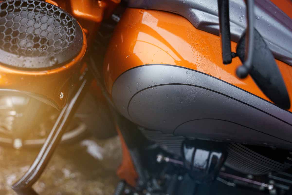 Orange motorcycle with custom sound system installed by Hear Me Coming Audio